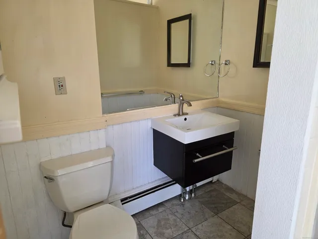 a bathroom with a toilet sink and mirror