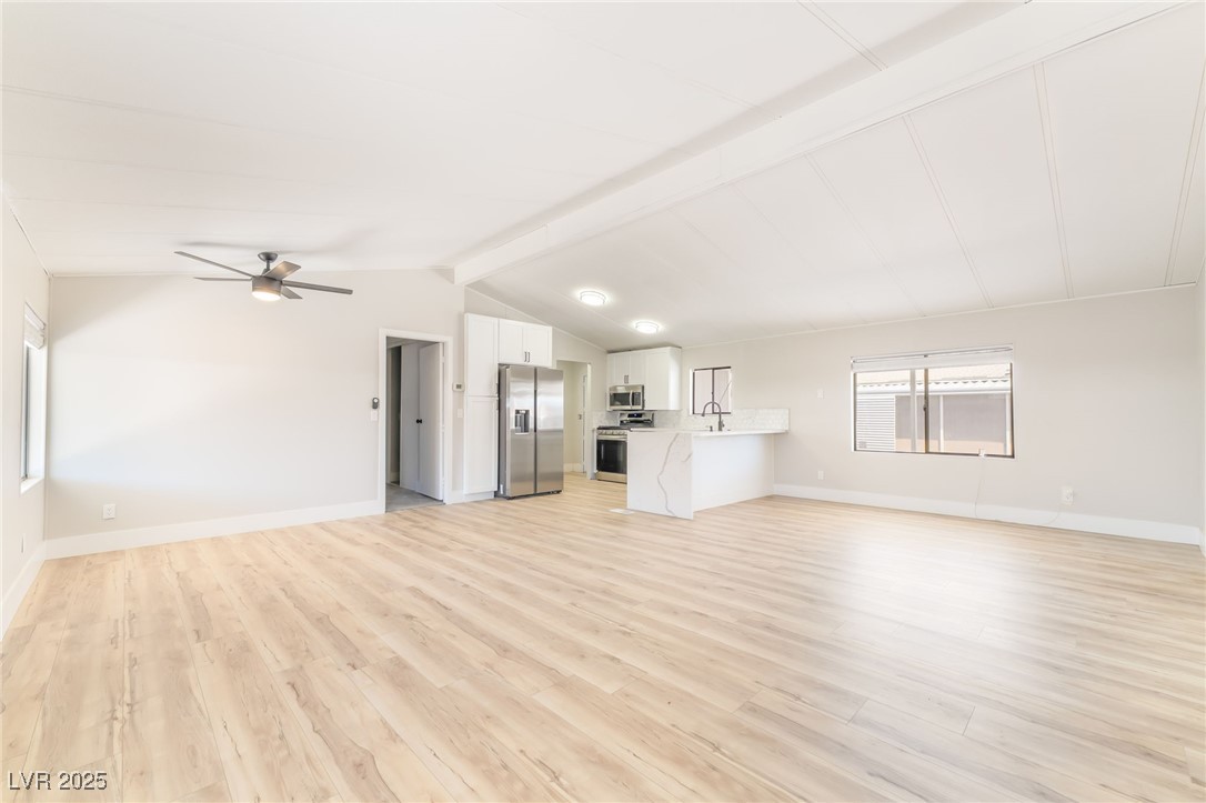 5552 Aldama Road Las Vegas, NV 89122 - Photo 14 of 35 Unfurnished living room featuring light wood-style floors and ceiling fan