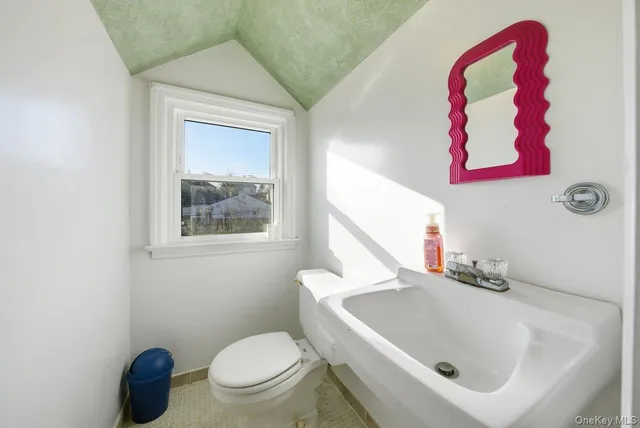 a bathroom with a toilet sink and mirror