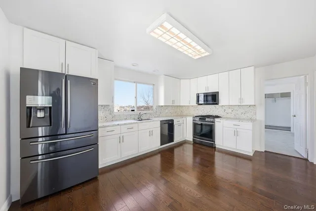 a kitchen with a refrigerator cabinets and wooden floor