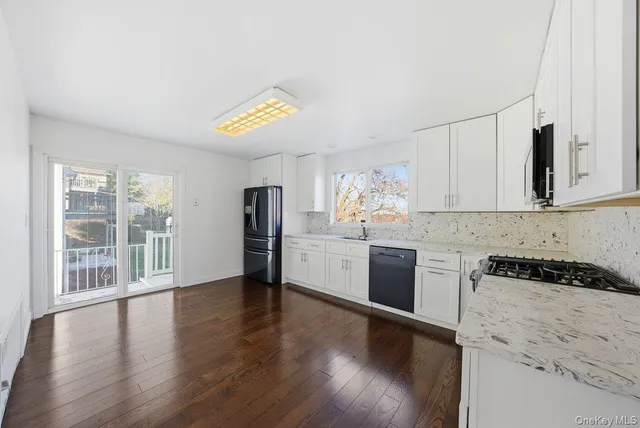 a kitchen with granite countertop a stove and wooden floor