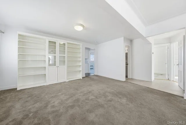 a view of an empty room with a closet and a window