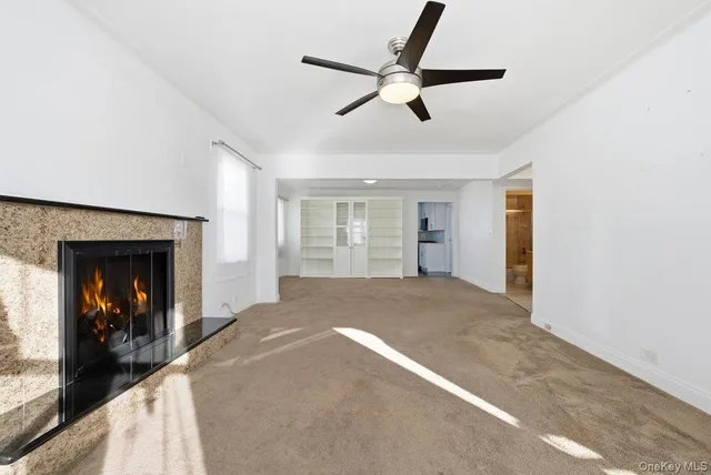 a view of a livingroom with a ceiling fan and window