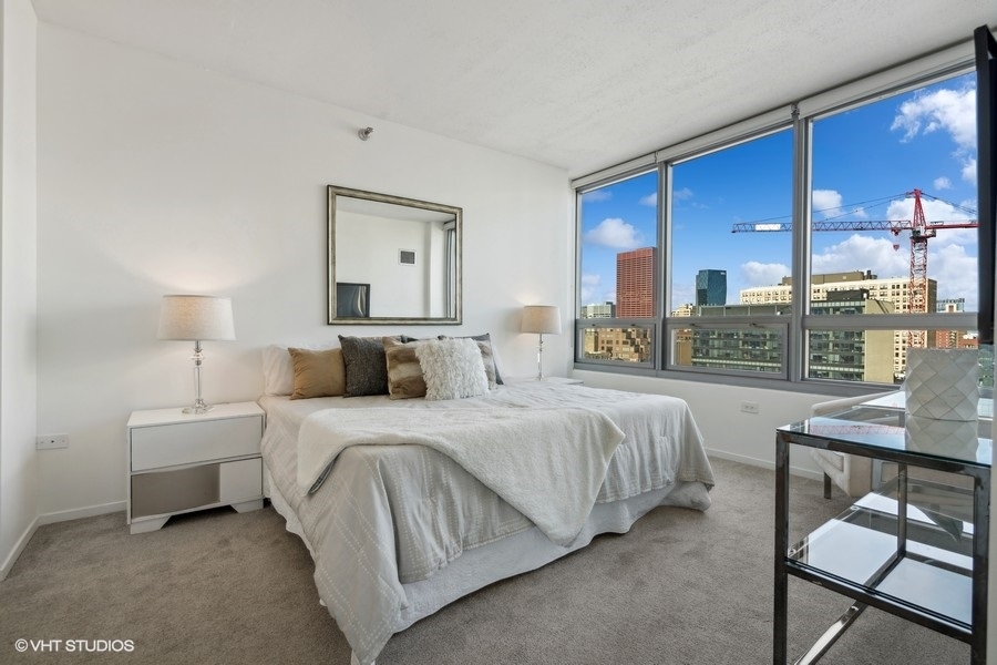701 South Wells Street, Unit 1904 Chicago, IL 60607 - Photo 11 of 22 a bedroom with a bed and a table