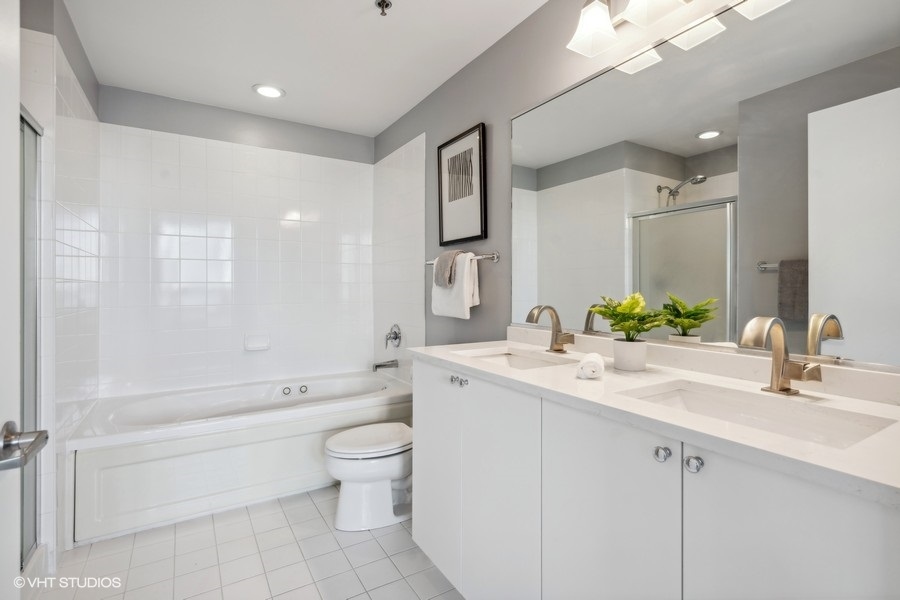 701 South Wells Street, Unit 1904 Chicago, IL 60607 - Photo 12 of 22 a bathroom with a granite countertop sink a toilet a mirror and shower