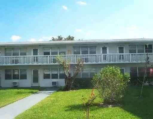 a front view of a house with a yard and potted plants