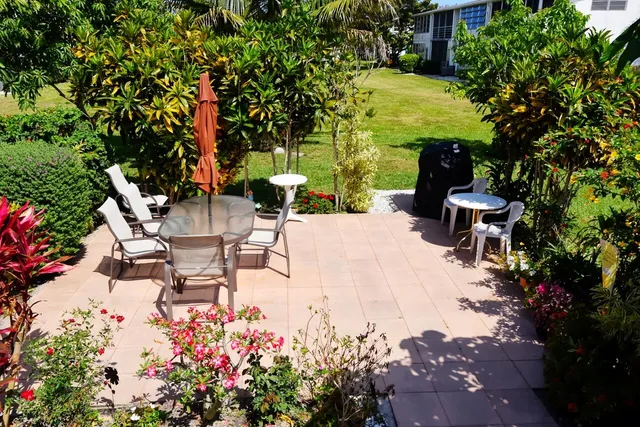 a view of a patio with table and chairs and potted plants