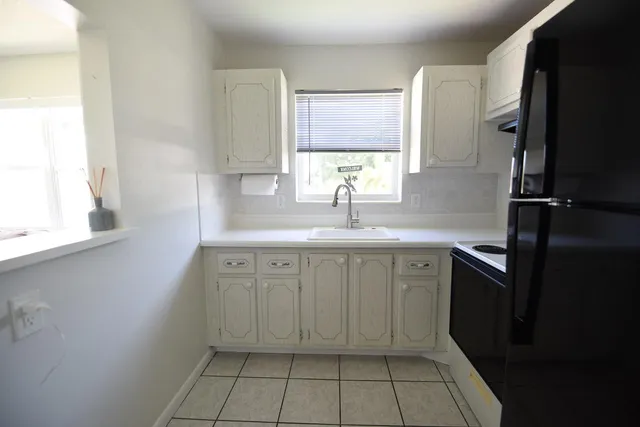 a kitchen with a sink cabinets and window