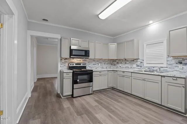 a kitchen with granite countertop white cabinets and stainless steel appliances
