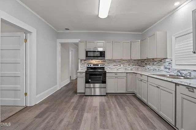 a kitchen with granite countertop a stove top oven and cabinets