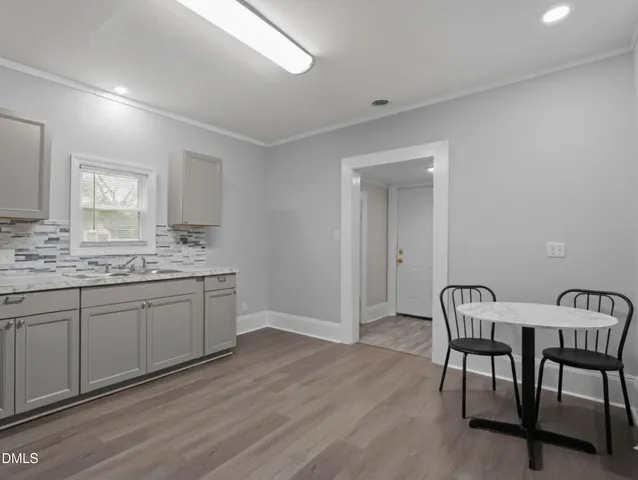 a kitchen with granite countertop white cabinets dining table and chairs