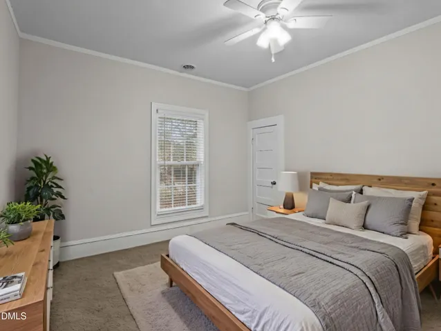 a bedroom with a bed and a potted plant