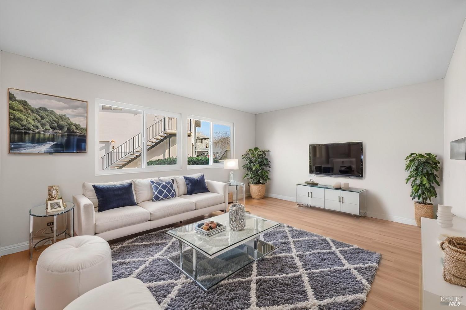 a living room with furniture a rug and a flat screen tv