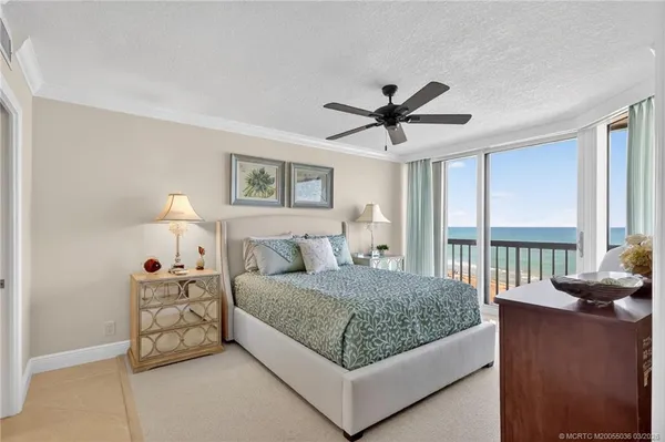 a bedroom with a bed a couch and a large window