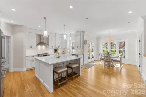 a kitchen with kitchen island a stove a sink a refrigerator and white cabinets