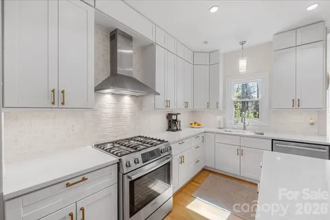 a large kitchen with kitchen island a sink a stove a refrigerator and a dining table with wooden floor