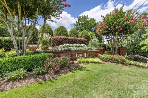 an aerial view of a house with swimming pool and large trees