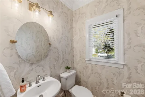 a kitchen with stainless steel appliances granite countertop a kitchen island a stove a refrigerator a sink a dining table and chairs with wooden floor