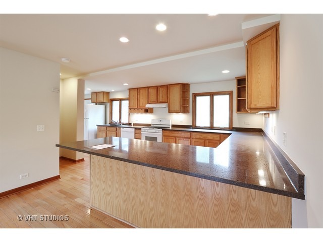 21 South Elmhurst Road Prospect Heights, IL 60070 - Photo 4 of 13 a kitchen with stainless steel appliances granite countertop a sink refrigerator and cabinets