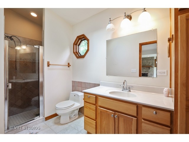 21 South Elmhurst Road Prospect Heights, IL 60070 - Photo 7 of 13 a bathroom with a sink a toilet and a mirror