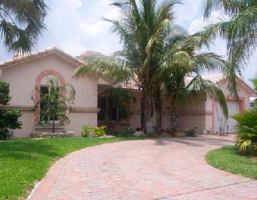 1341 Southwest 5th Avenue Boca Raton, FL 33432 - Photo 1 of 4 a front view of a house with a garden and palm trees