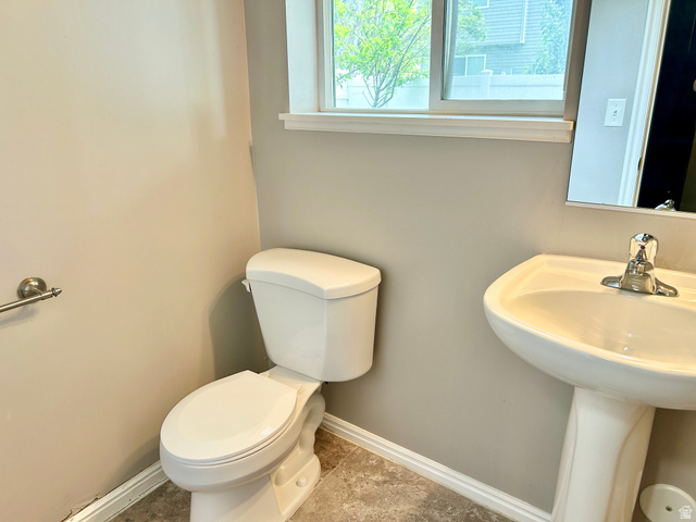 672 West 720 South Logan, UT 84321 - Photo 11 of 15 Bathroom featuring a pedestal sink with a chrome faucet, a standard toilet, and a window providing natural light