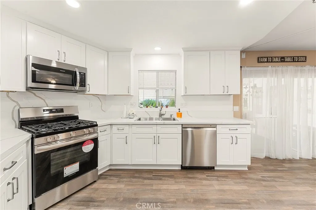 35218 Fir, Unit 183 Yucaipa, CA 92399 - Photo 11 of 35 a kitchen with stainless steel appliances a stove a sink and a microwave