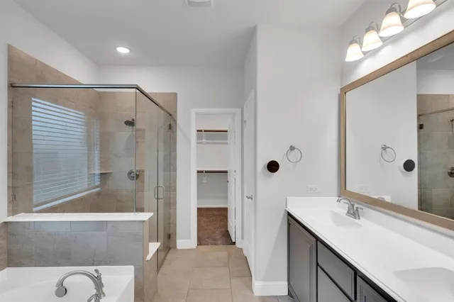 a bathroom with a tub sink and mirror