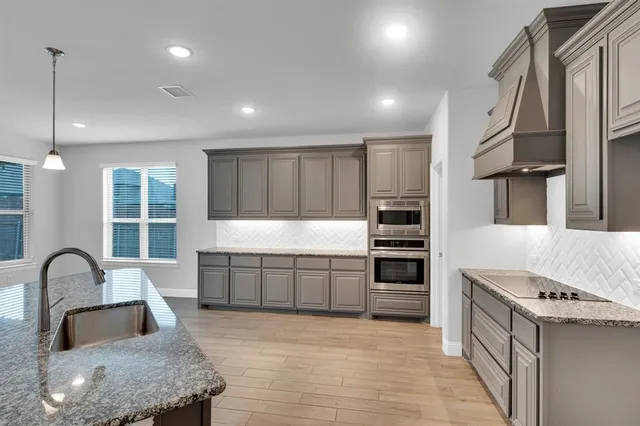 a kitchen with a sink appliances and cabinets