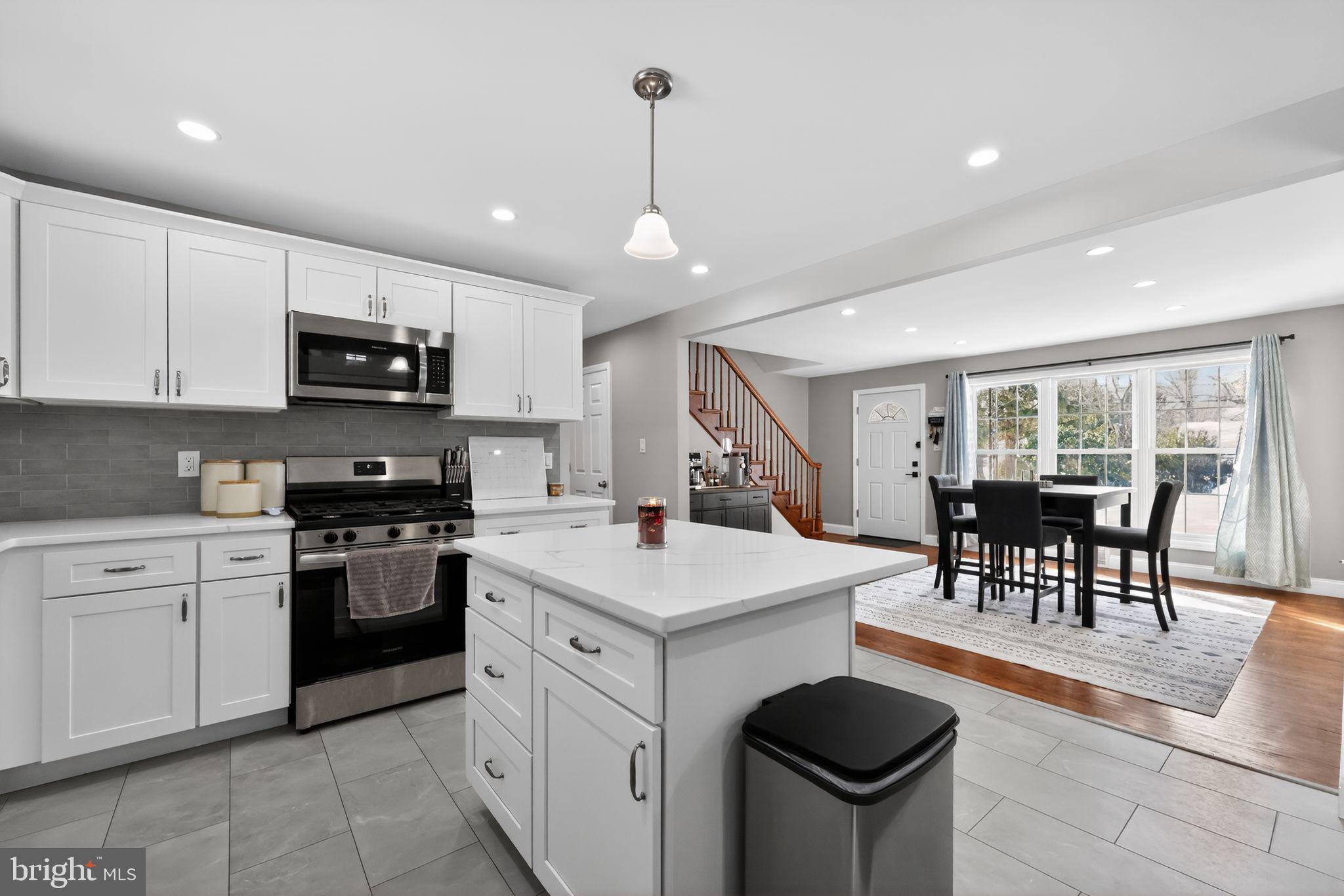 298 South Tuckahoe Road Williamstown, NJ 08094 - Photo 9 of 22 a kitchen with stainless steel appliances granite countertop a stove top oven a sink dishwasher a dining table and chairs with wooden floors