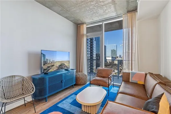 a living room with furniture a rug and a window