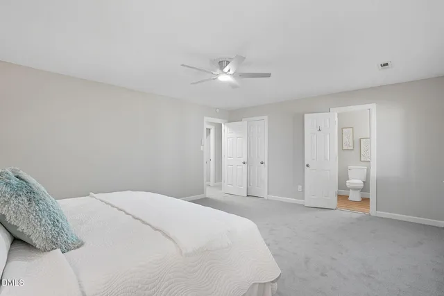 a spacious bedroom with a bed and a ceiling fan