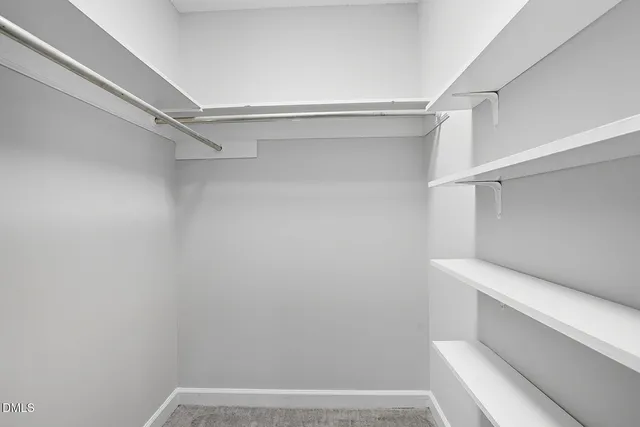 a view of walk in closet with empty racks