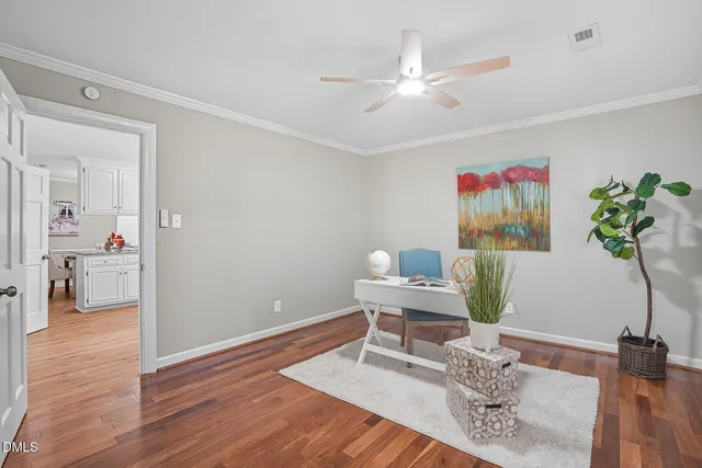 a workspace with furniture a potted plant and wooden floor
