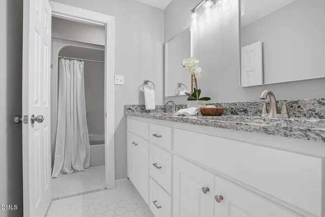 a bathroom with cabinets sink and mirror