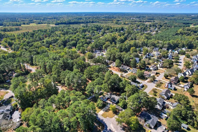 an aerial view of a houses with a yard and mountain