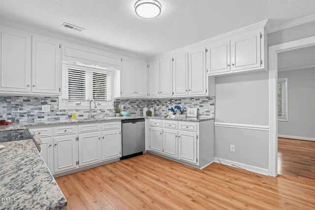 a kitchen with granite countertop white cabinets and white appliances