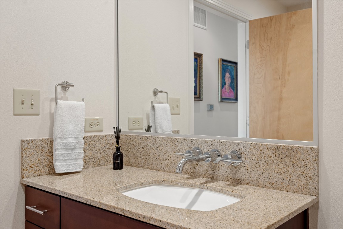 1600 Barton Springs Road, Unit 5301 Austin, TX 78704 - Photo 15 of 30 a bathroom with a granite countertop sink and a mirror