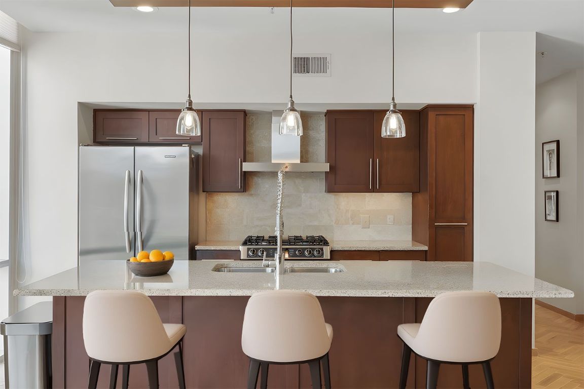 1600 Barton Springs Road, Unit 5301 Austin, TX 78704 - Photo 2 of 30 a kitchen with stainless steel appliances granite countertop a sink a refrigerator and chairs