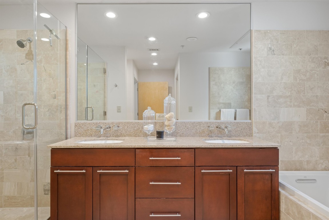 1600 Barton Springs Road, Unit 5301 Austin, TX 78704 - Photo 8 of 30 a bathroom with a granite countertop sink a mirror and a shower