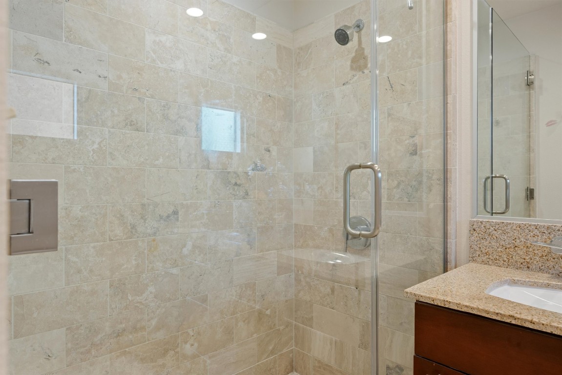 1600 Barton Springs Road, Unit 5301 Austin, TX 78704 - Photo 9 of 30 a bathroom with a granite countertop shower a sink and a mirror