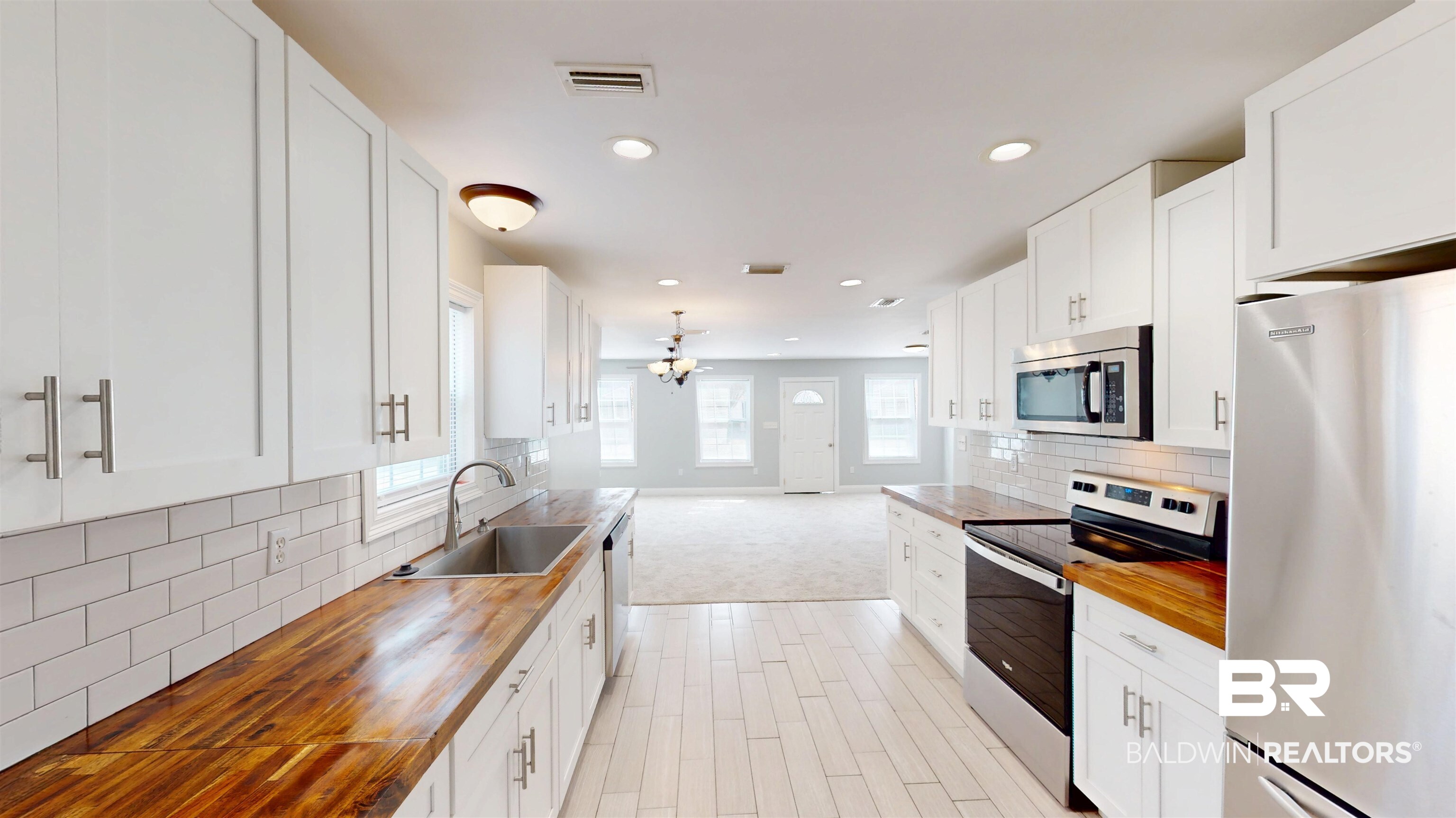 2454 Taylor Avenue Mobile, AL 36606 - Photo 10 of 24 Kitchen with stainless steel appliances, wooden counters, white cabinets, and backsplash