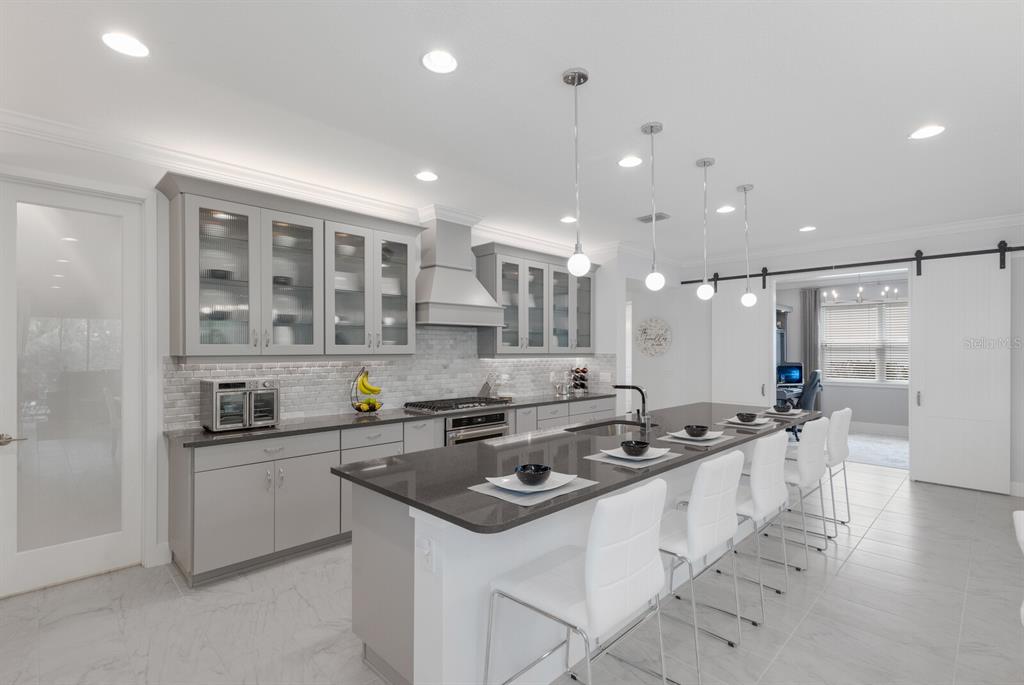 5557 Long Shore Loop Sarasota, FL 34238 - Photo 18 of 90 a kitchen that has a sink a stove and chairs