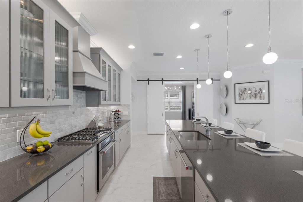 5557 Long Shore Loop Sarasota, FL 34238 - Photo 19 of 90 a kitchen with stainless steel appliances granite countertop a stove and cabinets