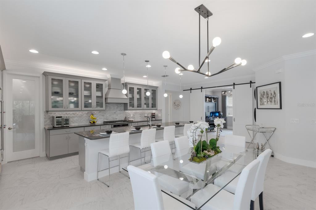 5557 Long Shore Loop Sarasota, FL 34238 - Photo 2 of 90 a kitchen with stainless steel appliances kitchen island granite countertop a stove a sink a refrigerator and white cabinets with wooden floor