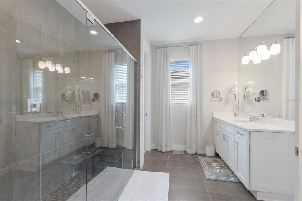 5557 Long Shore Loop Sarasota, FL 34238 - Photo 25 of 90 a bathroom with a double vanity sink mirror and shower