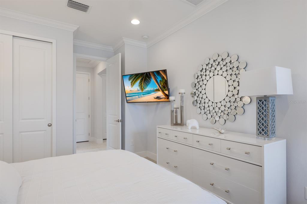 5557 Long Shore Loop Sarasota, FL 34238 - Photo 31 of 90 a bedroom with a bed and a flat tv screen in it