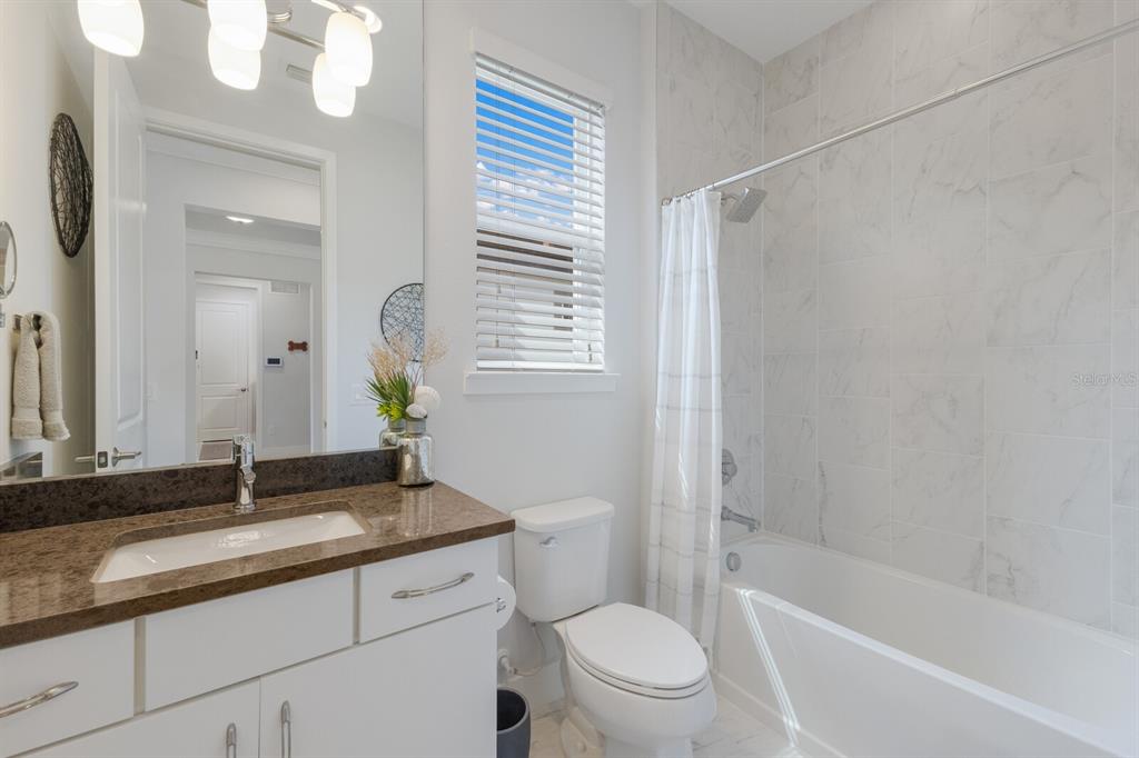 5557 Long Shore Loop Sarasota, FL 34238 - Photo 32 of 90 a bathroom with a granite countertop sink a toilet and shower