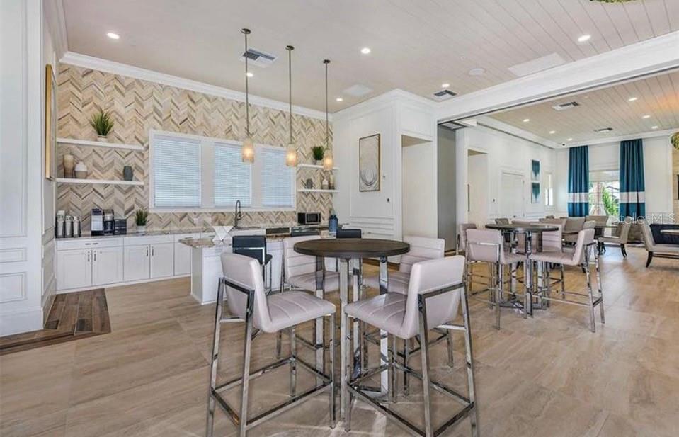 5557 Long Shore Loop Sarasota, FL 34238 - Photo 71 of 90 a kitchen with stainless steel appliances kitchen island granite countertop a table and chairs in it