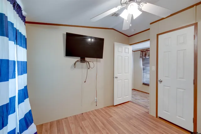 a view of a livingroom with wooden floor and a flat screen tv